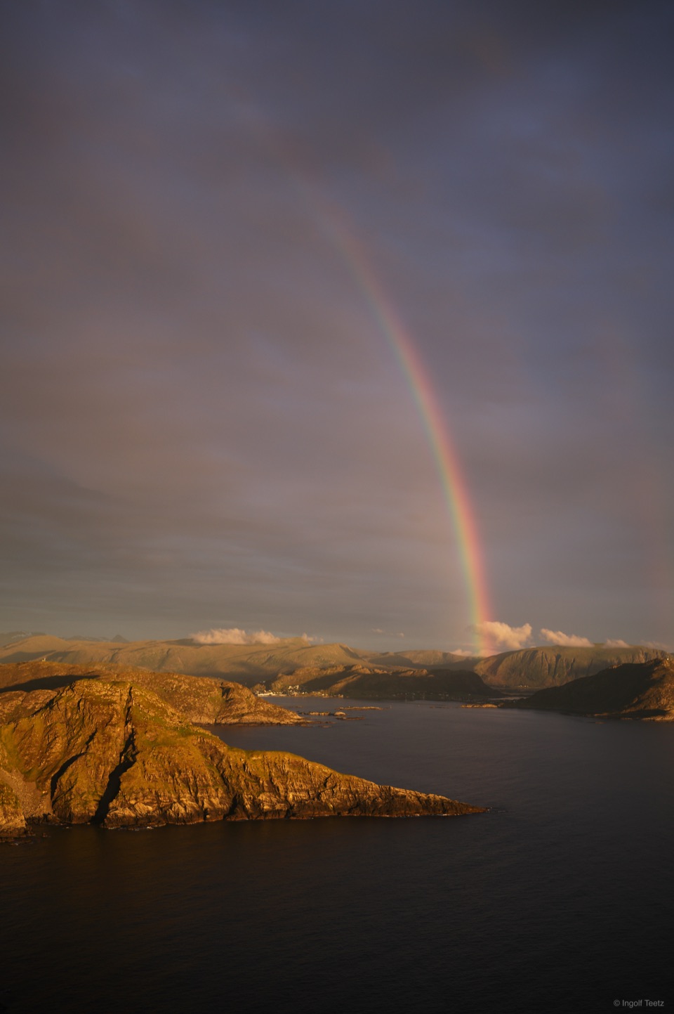 Regenbogen über den golden beleuchteten Klippen von Runde am späten Abend